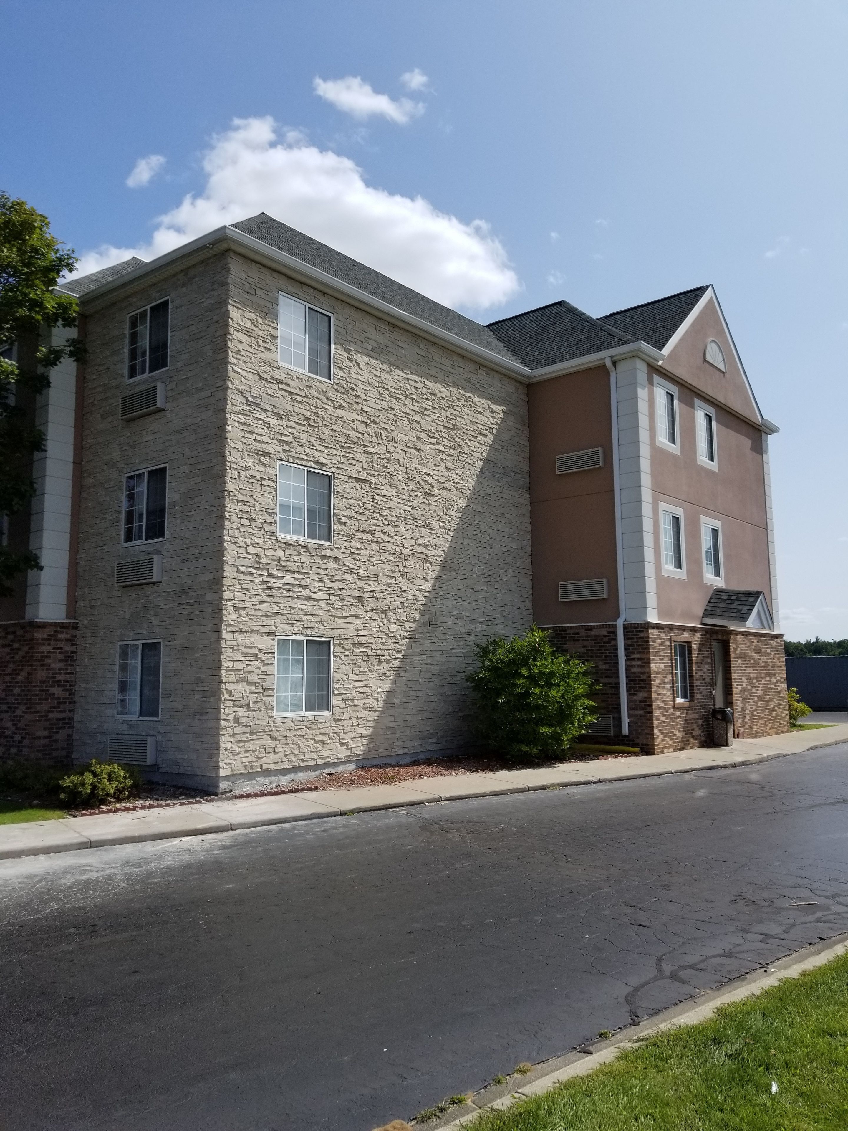 A multi-story building with a stone facade and a brown upper section.