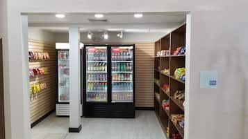 A clean, well-lit store with shelves stocked with snacks and beverages, including Coca-Cola.