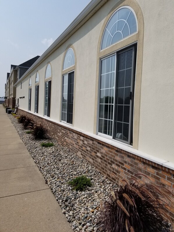 A row of buildings with large arched windows and a brick base. - Holiday Inn Express Birch Run - Frankenmuth Area by IHG (Birch Run)