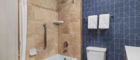 Un baño con bañera, ducha e inodoro.