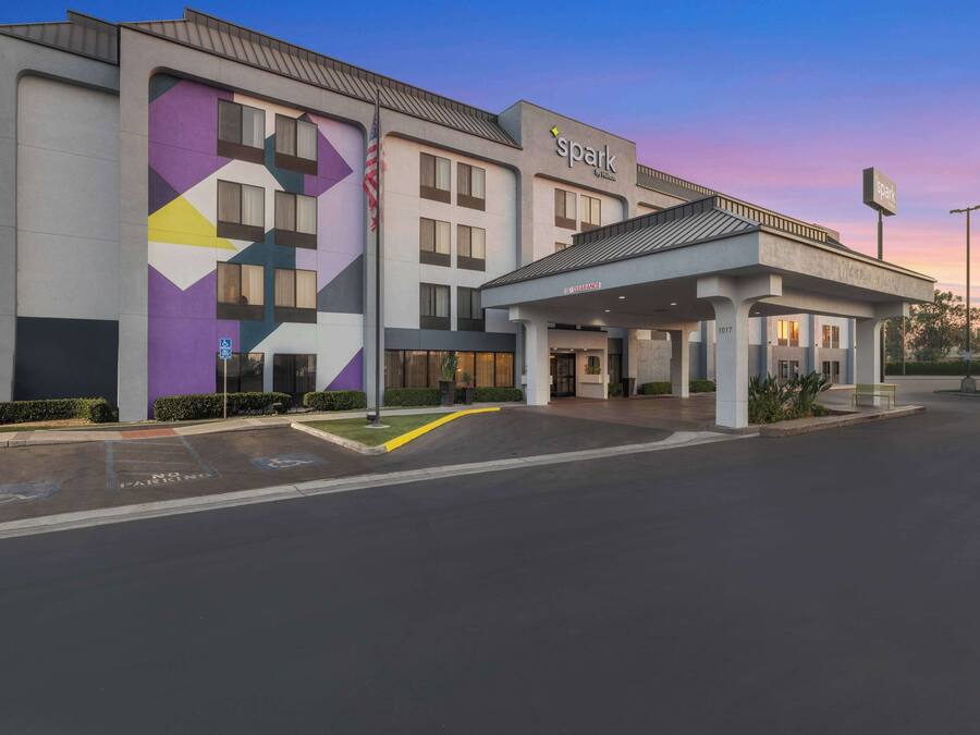 A hotel with a modern design, featuring a geometric facade and a covered entrance.