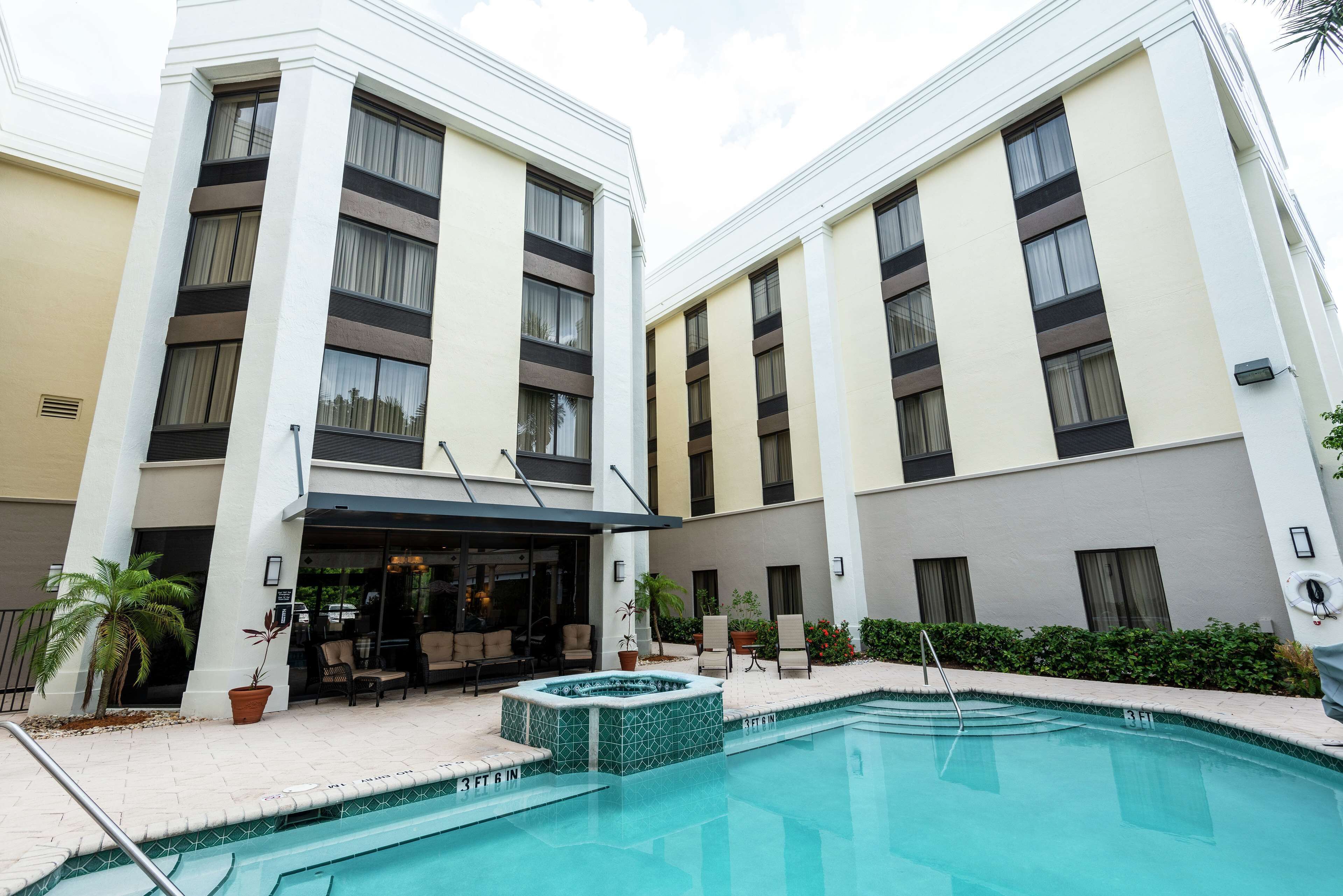 Ein Hotel mit Swimmingpool, Außenbereich und einer überdachten Terrasse.