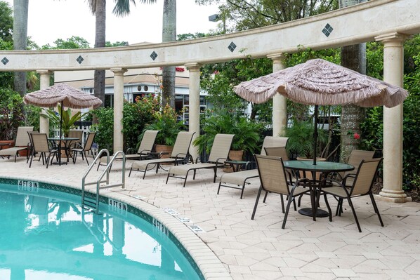 Alberca al aire libre y camastros 