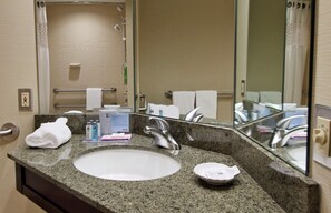 Bathroom features a granite countertop sink, towel rack, and shower area.