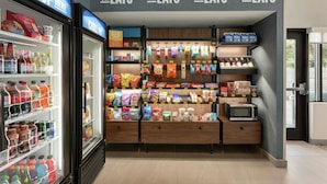 A snack and beverage section with shelves stocked with snacks, drinks, and a microwave. - Hampton Inn Hagerstown (Hagerstown)