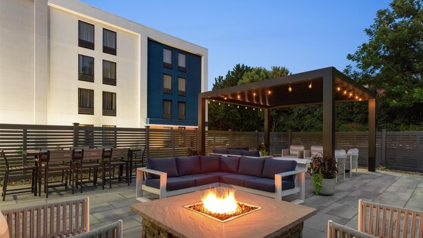 A patio area with a fire pit, outdoor seating, and a pergola with string lights. - Hampton Inn Hagerstown (Hagerstown)