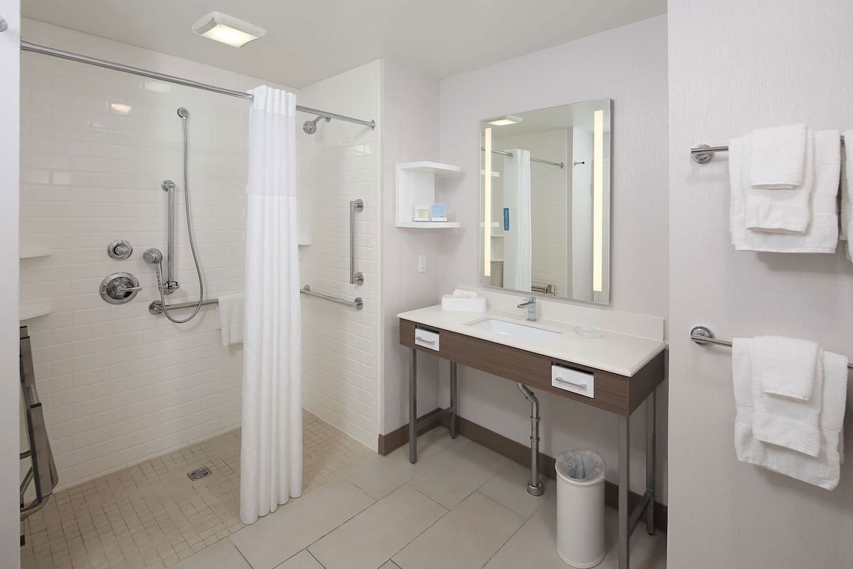 A modern bathroom with a shower, toilet, and sink.