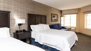 A hotel room with a large bed, a bedside table with a lamp, a chair, and a window with curtains.