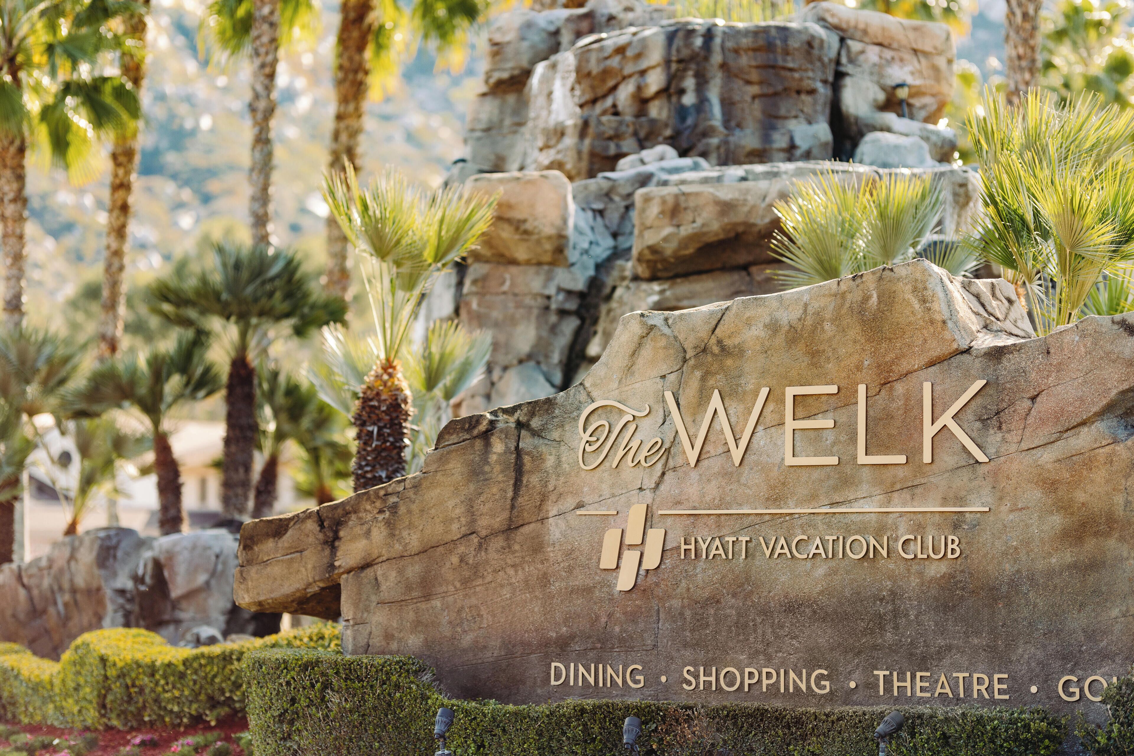 Une enseigne indiquant « The WELK, Hyatt Vacation Club », avec la mention des services proposés : restaurants, boutiques, théâtre et terrain de golf.