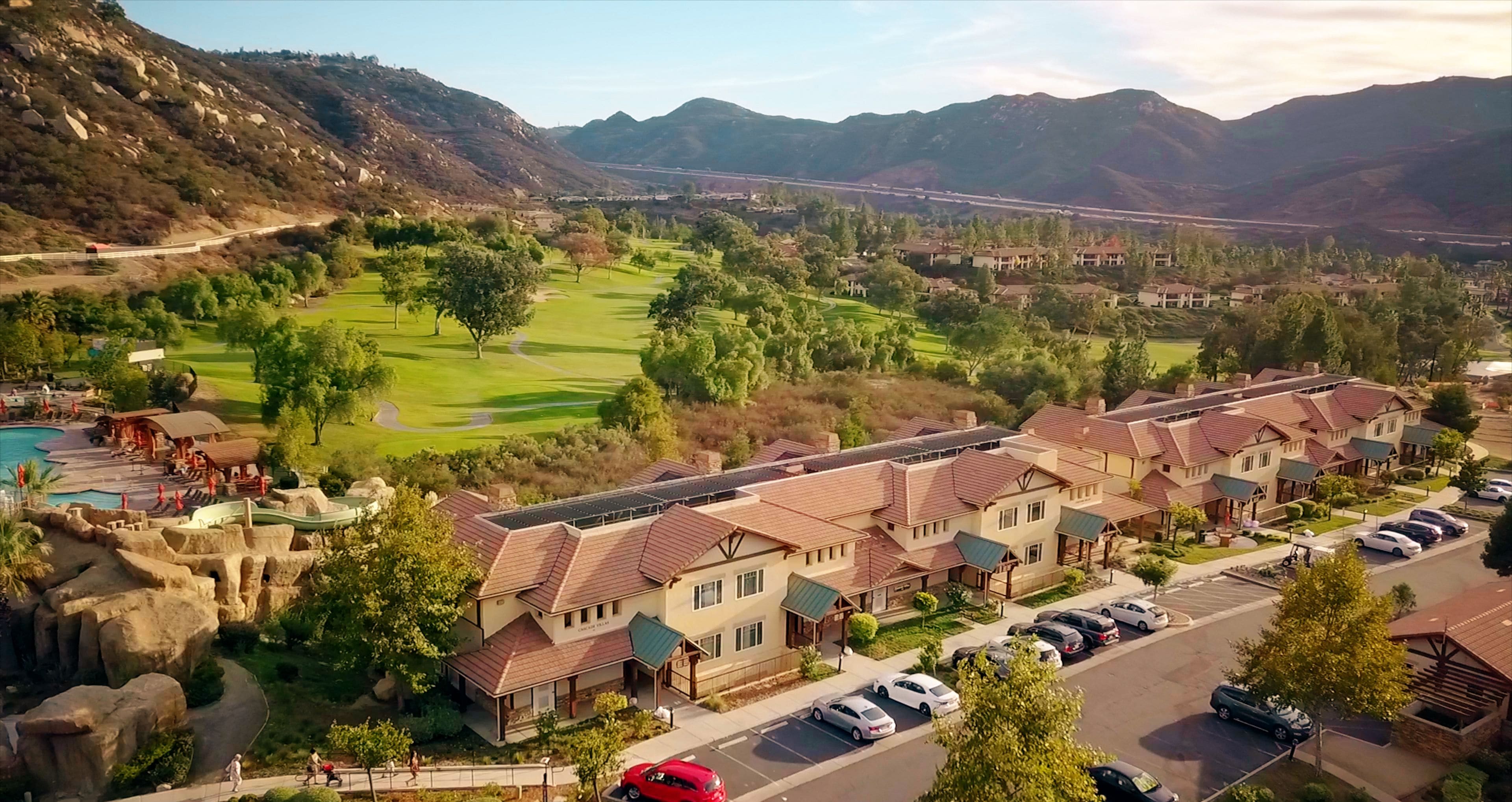 A residential area with houses, a golf course, and a road.