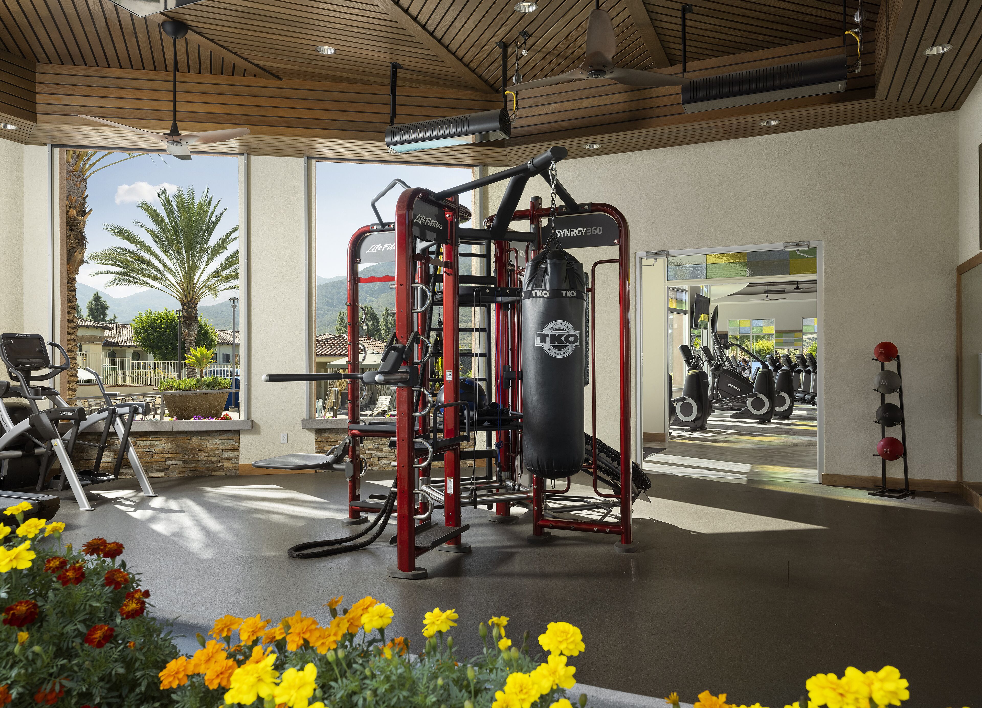 A gym with exercise equipment, a punching bag, and a view of the outdoors.