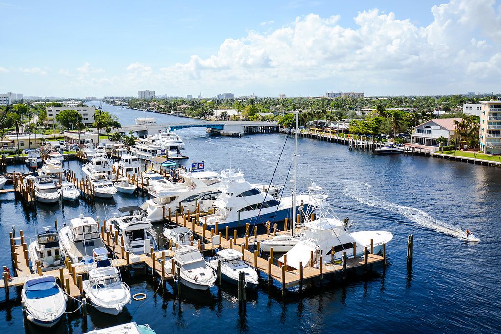A marina with multiple boats docked at wooden piers.