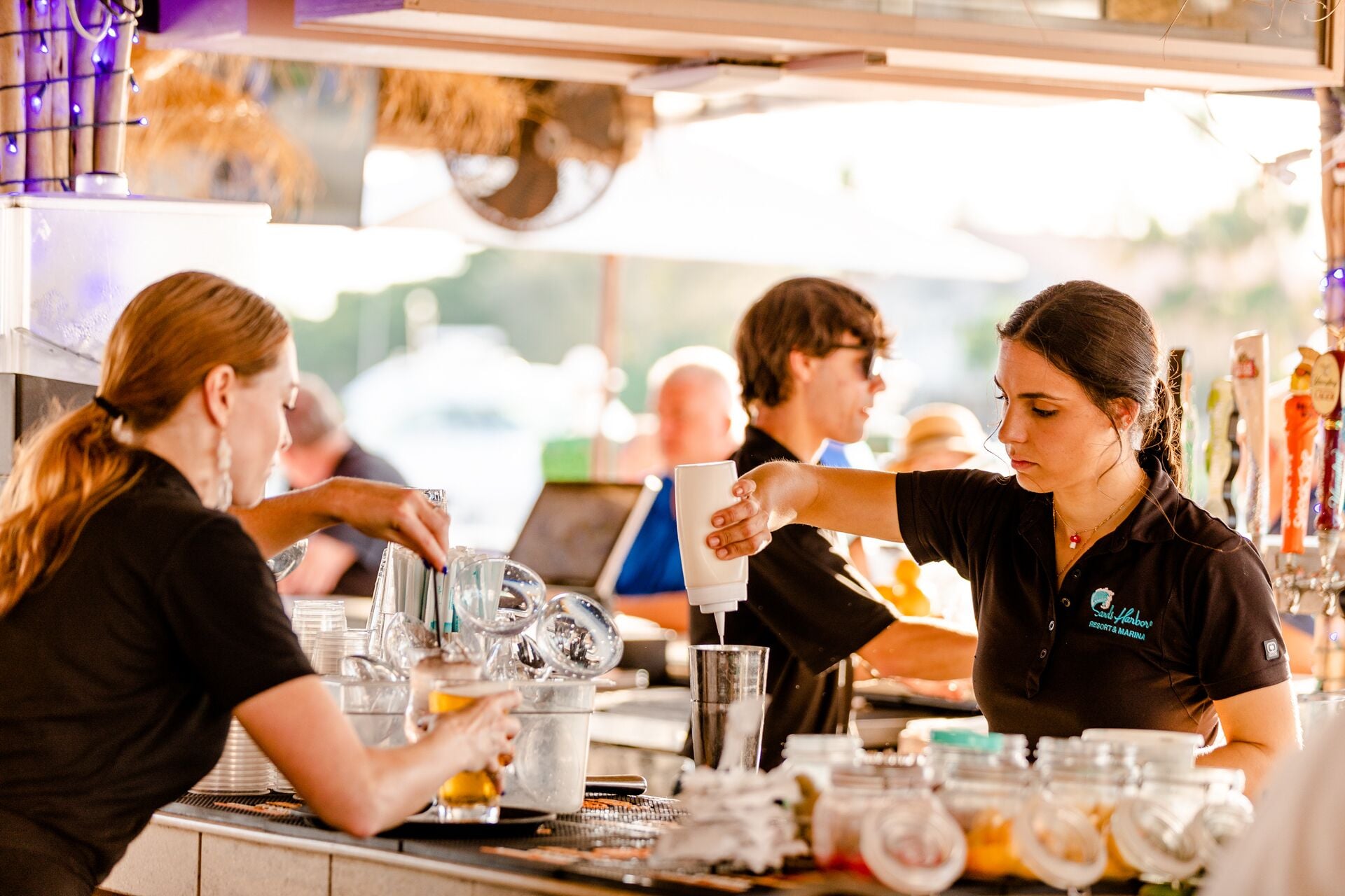 Una zona de bar con un barman preparando bebidas.