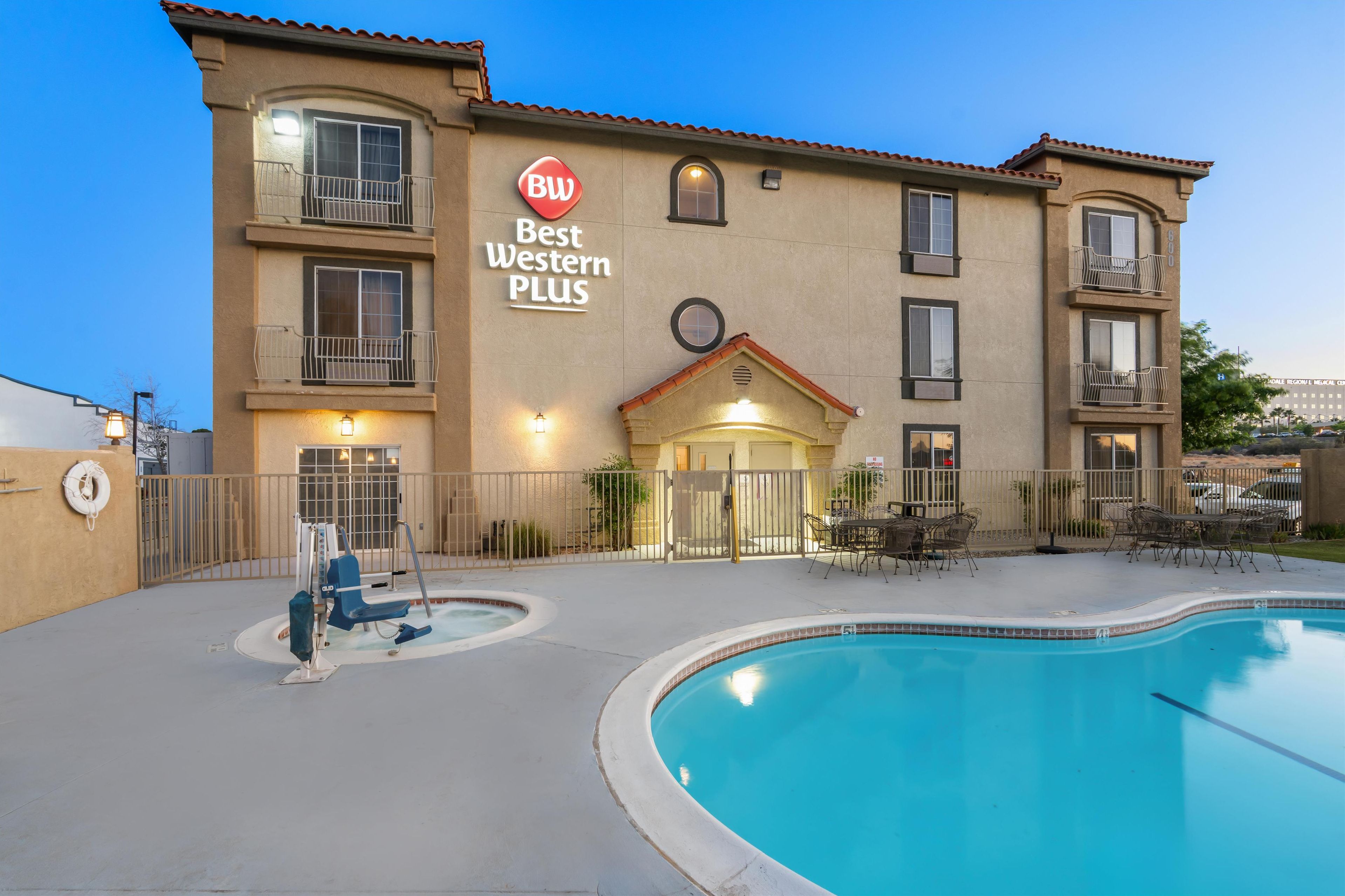A hotel with a pool, outdoor seating, and a sign reading "Best Western PLUS".