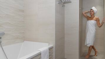 Un baño moderno con bañera, ducha y toallero.