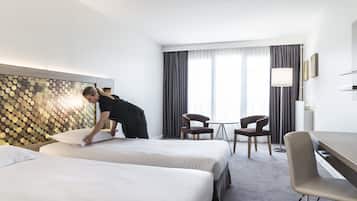 Une chambre d’hôtel avec deux lits, un bureau et une chaise.