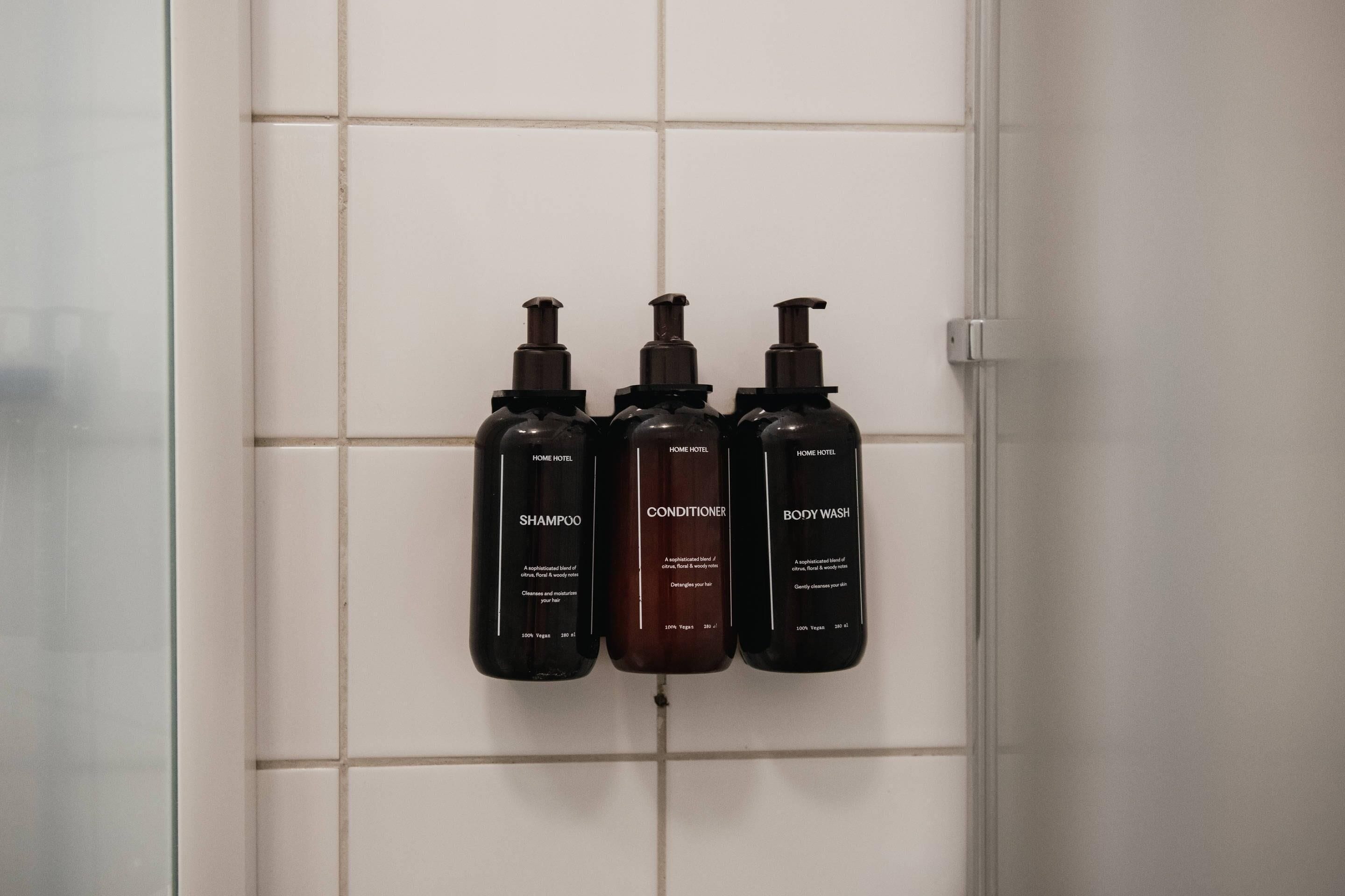 Drei Toilettenartikel auf einer gefliesten Wand.