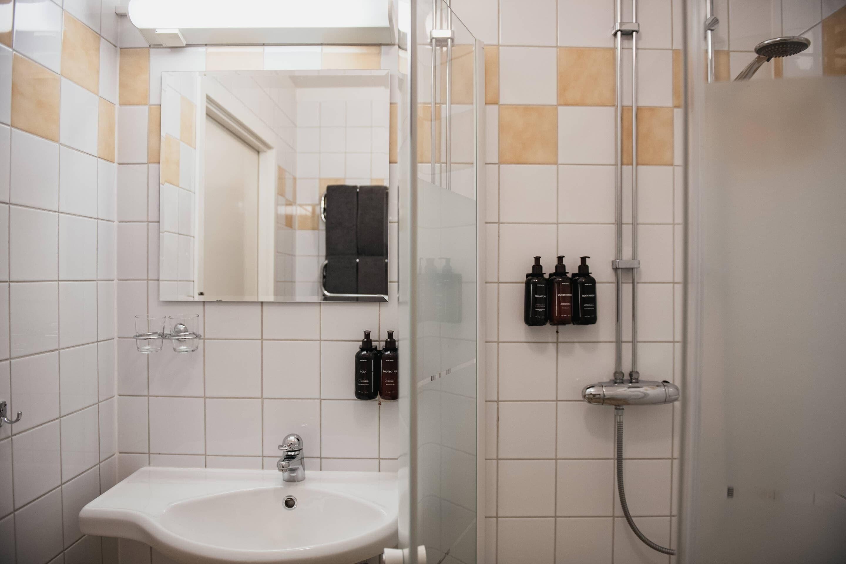 Un bagno con lavandino, specchio e doccia.