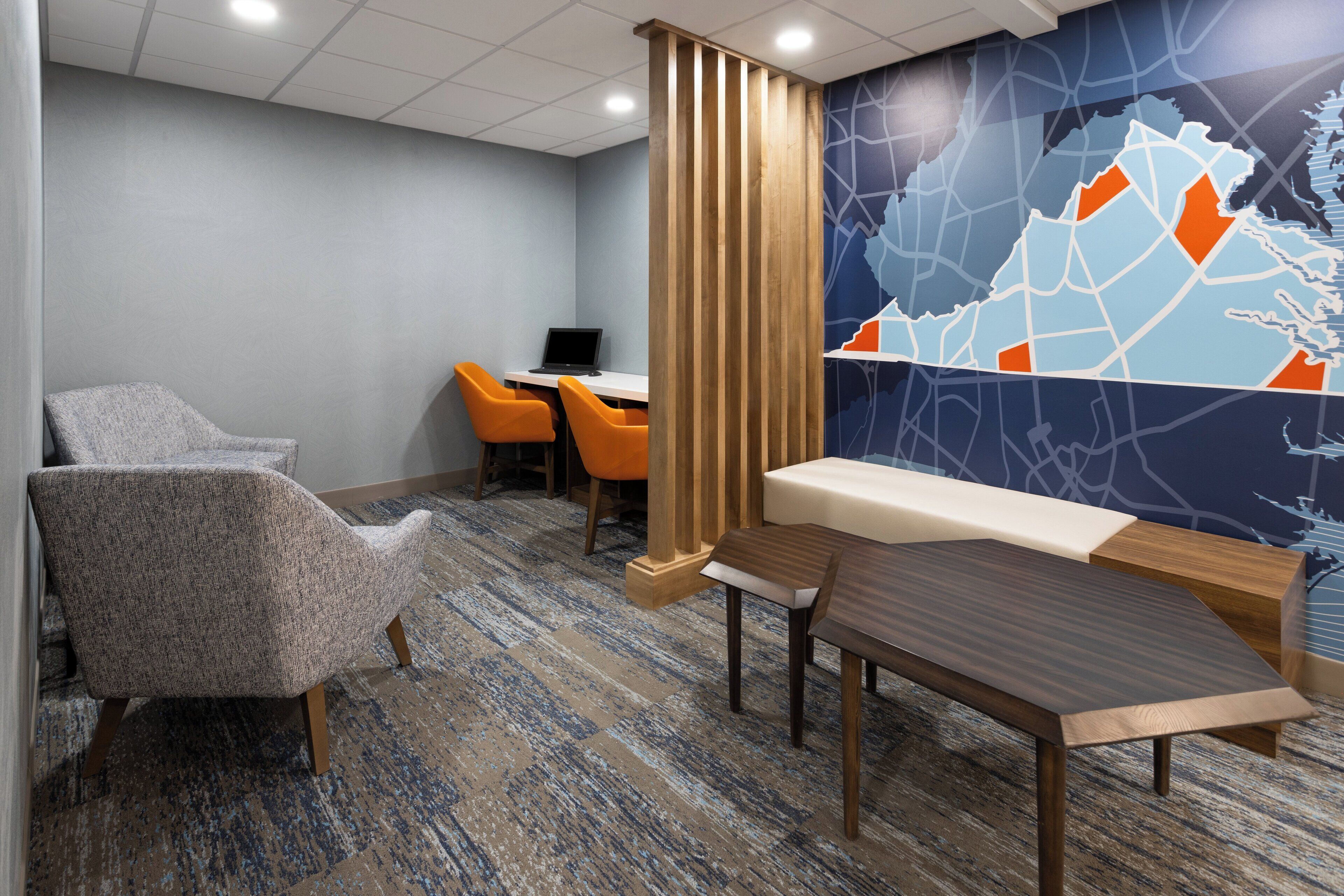 Un salón de conferencias con un mural de mapa, un separador de madera y mobiliario moderno.