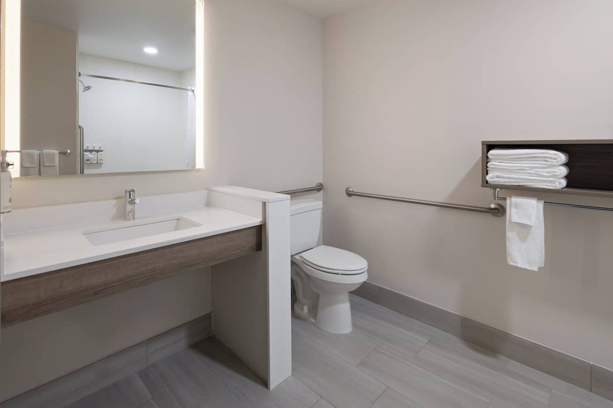 A modern bathroom with a sink, toilet, and a towel rack.