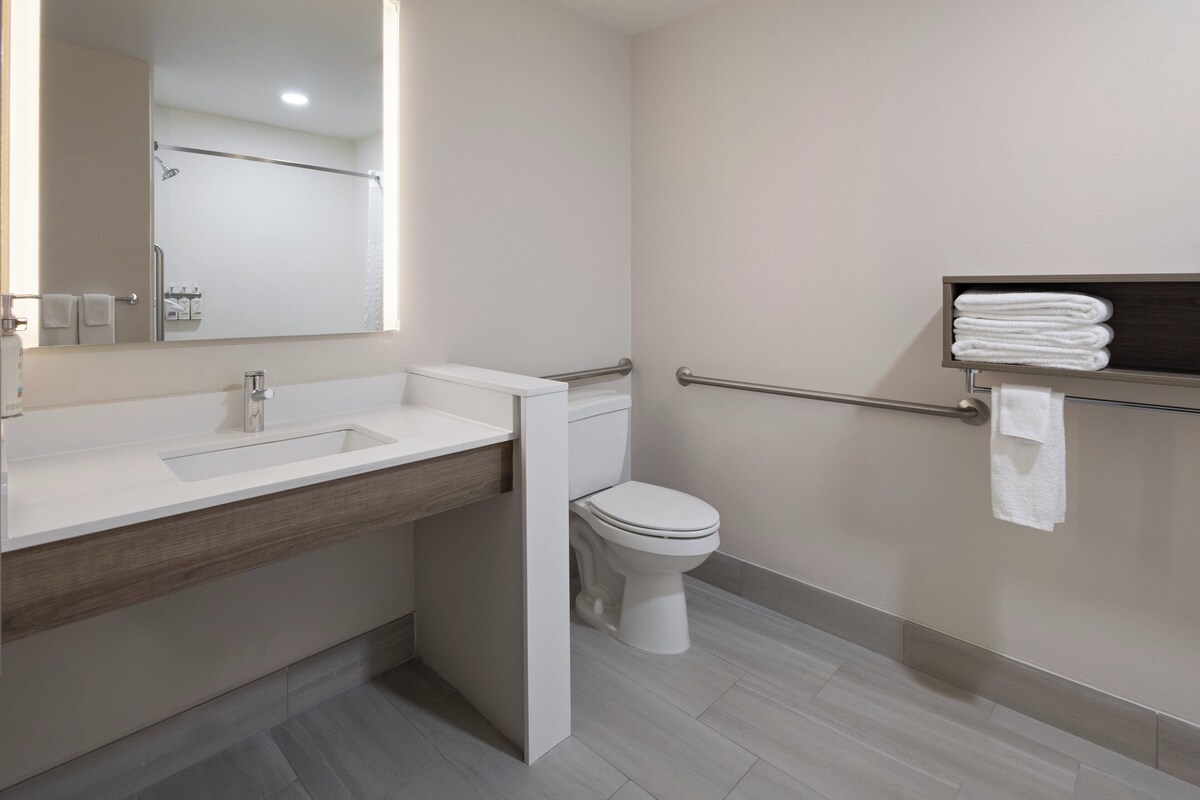 A modern bathroom with a sink, toilet, and a towel rack.