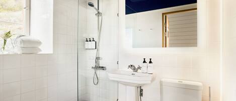 A bathroom with a shower, sink, and toilet.