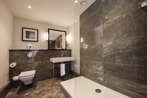 A modern bathroom with a toilet, sink, and shower area.
