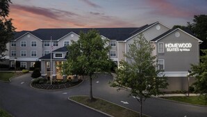 A hotel with a modern design, featuring a prominent sign for "HOMEWOOD SUITES by Hilton."