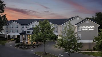 Um hotel com design moderno, exibindo uma placa chamativa para "HOMEWOOD SUITES by Hilton".