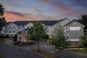 Un hôtel au design moderne, avec une enseigne bien visible indiquant « HOMEWOOD SUITES by Hilton ».