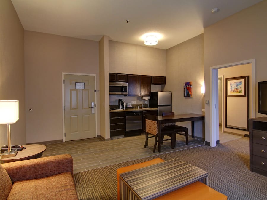 Quarto de hotel compacto com cozinha compacta, área de jantar, espaço para sentar e televisão.