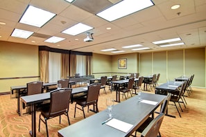 A conference room with multiple tables and chairs, a projector, and a large window with curtains. - Homewood Suites by Hilton Houston-Kingwood Parc-Airport Area (Kingwood)