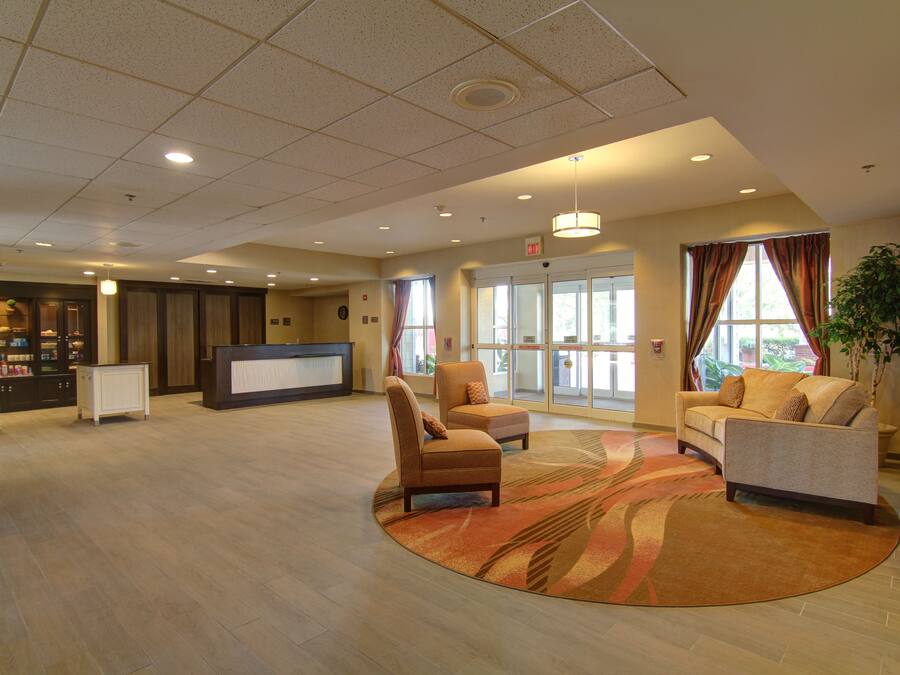 A spacious lobby with a reception desk, seating area, and large windows.