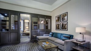 Una habitación de hotel moderna con un sofá, una mesa de centro, una lámpara y cuadros en la pared.