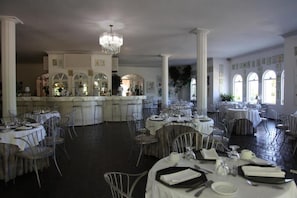 Enjoy dining in this elegant space with high ceilings, a central chandelier, and large windows.