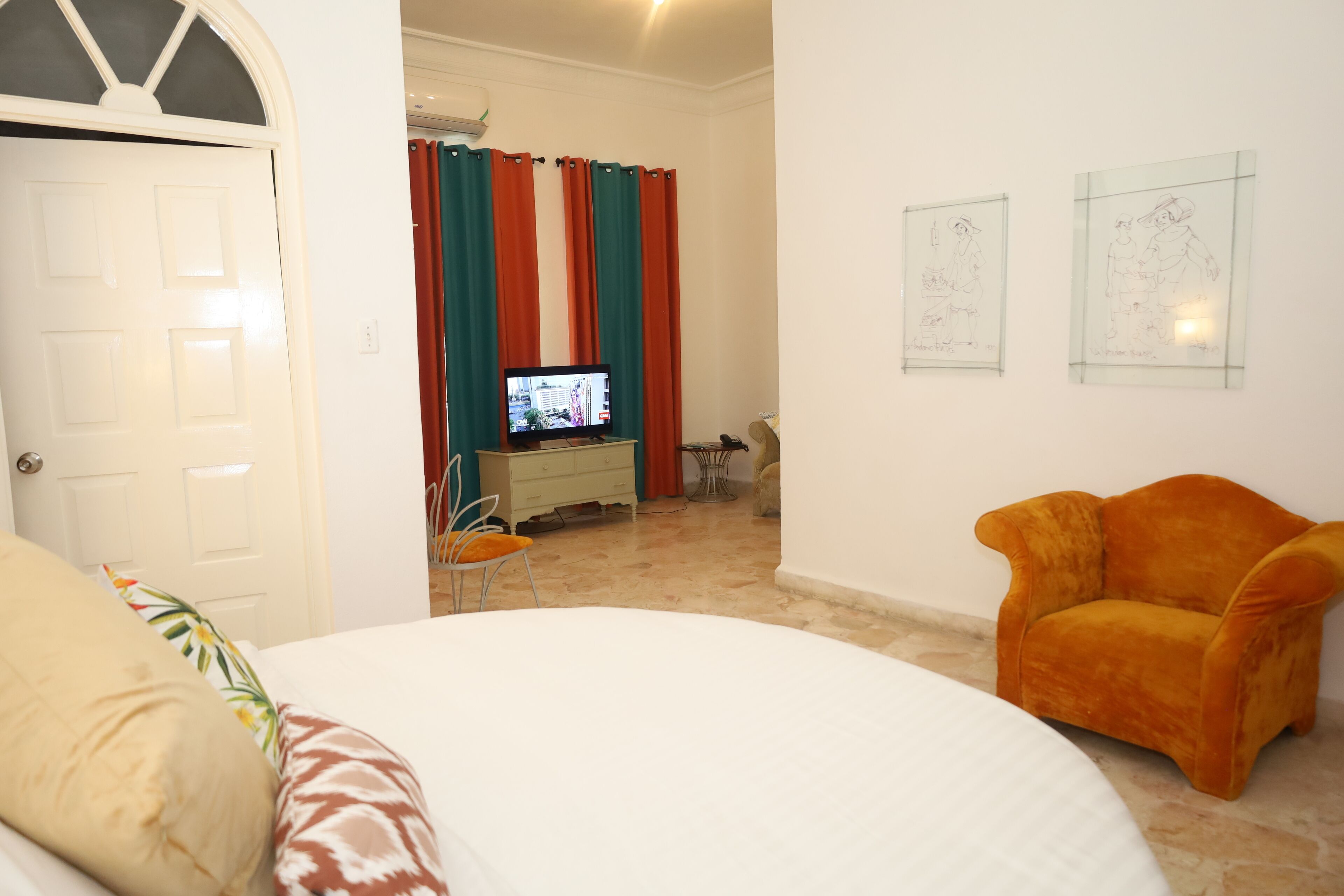 Une chambre d’hôtel avec un lit, une télévision, un bureau et une chaise.