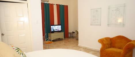A hotel room with a bed, a television, a desk, and a chair.