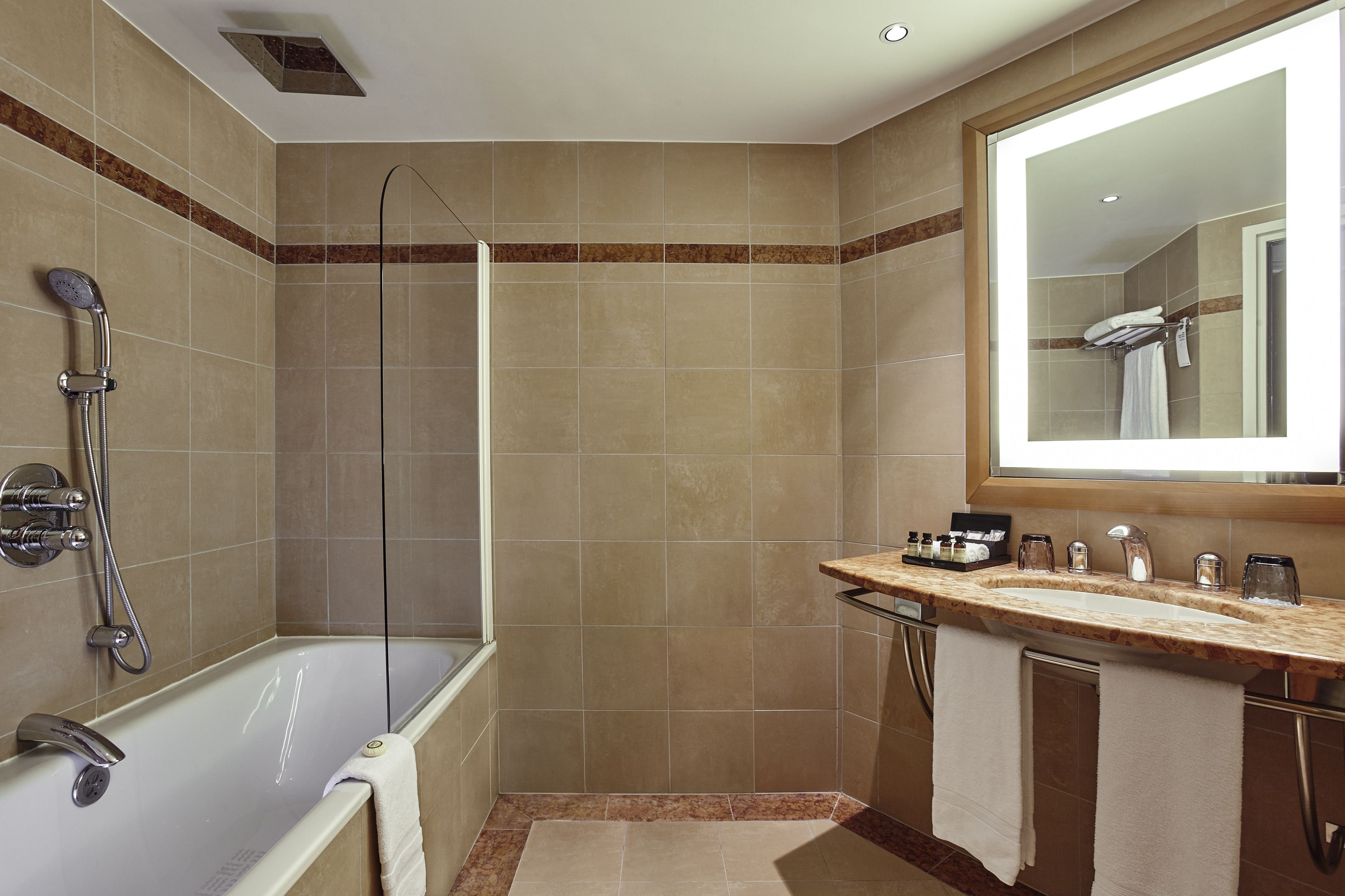 Een moderne badkamer met een badkuip, douche en wastafel met spiegel.