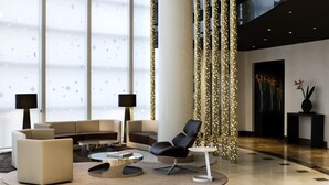 Un vestíbulo moderno con un sofá, sillones y una mesa de centro.