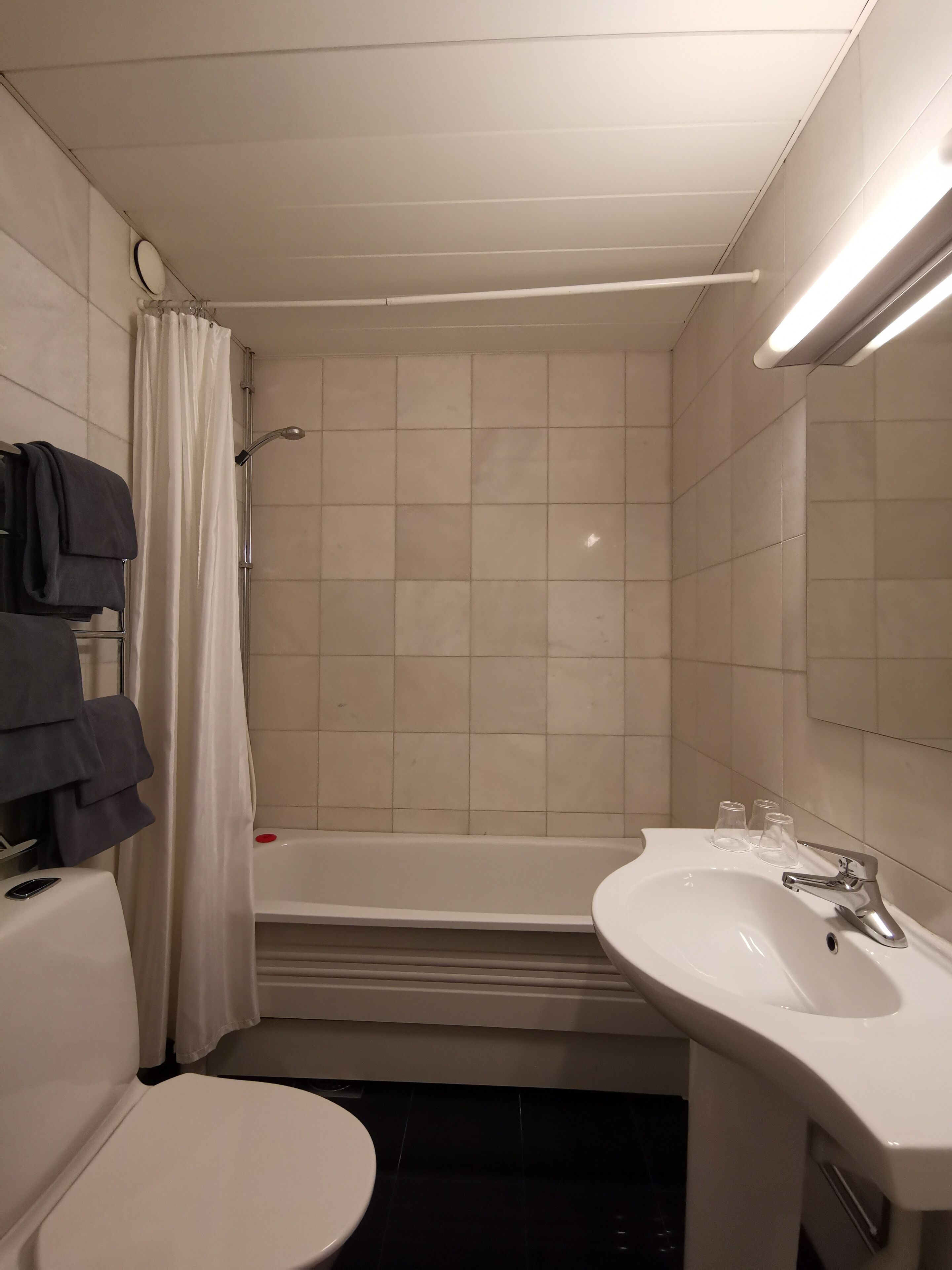 A bathroom with a toilet, sink, and bathtub.