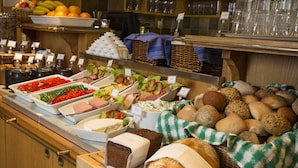 A buffet with various food items including bread, salads, and fruits.