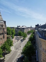 Vista de una calle con edificios históricos, un paso de peatones y cielo despejado.