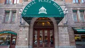 The Crystal Plaza Hotel entrance with a green awning and a classical architectural style.