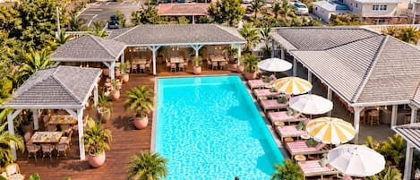 Un resort con piscina, mobiliario exterior y vistas al océano.