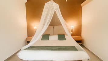 Un dormitorio con cama con dosel, dos mesitas de noche y una mesilla.