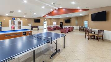 Relax and unwind in our spacious indoor recreational area, featuring a ping pong table, pool table, and billiards table, along with comfortable seating and a flat-screen TV.