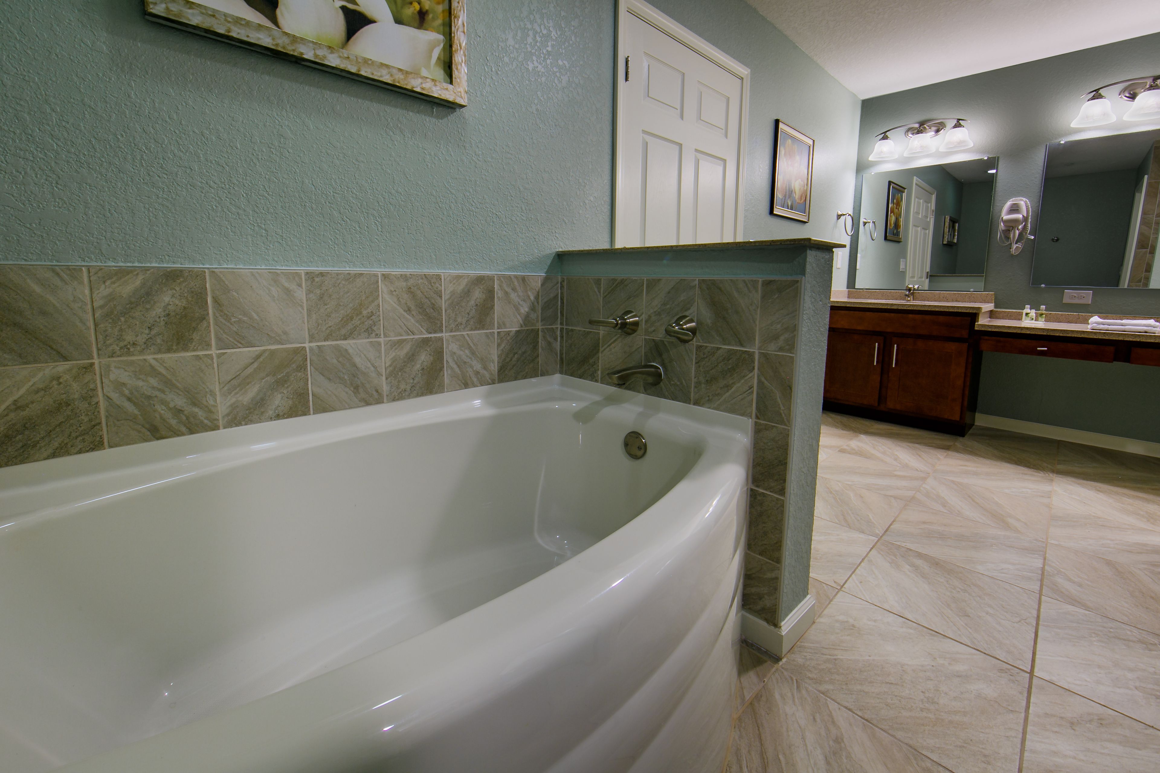 Un baño con bañera, lavabo y espejo.