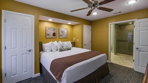 A hotel room with a large bed, a ceiling fan, and a shower area visible through an open door. - Holiday Inn Club Vacations Orlando Breeze Resort by IHG (Davenport)