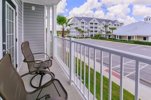Enjoy the view from this balcony with two comfortable chairs and a small table.