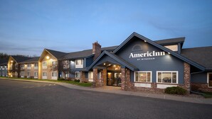 Un hotel dal design architettonico moderno, con un ingresso ben visibile caratterizzato da vetrate e una facciata in mattoni.